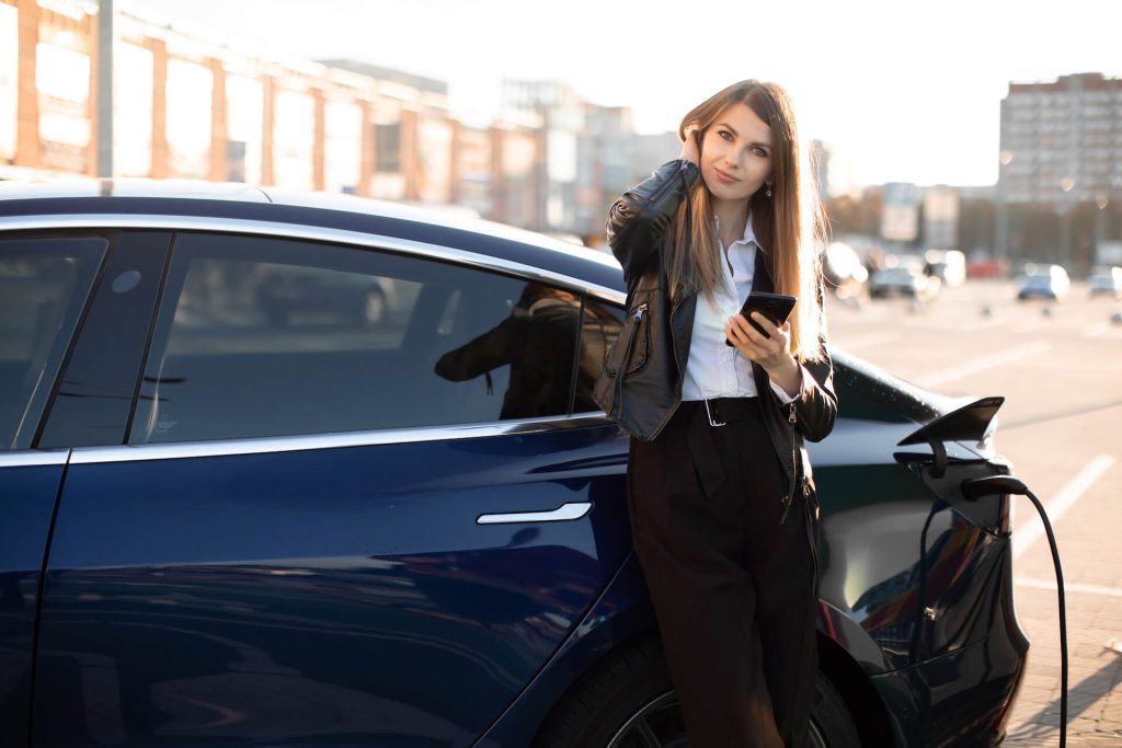 Woman Charging Electric Car | Featured Image for the Navigating the New Electric Cars for Sale Market blog from Sell My Car Queensland.