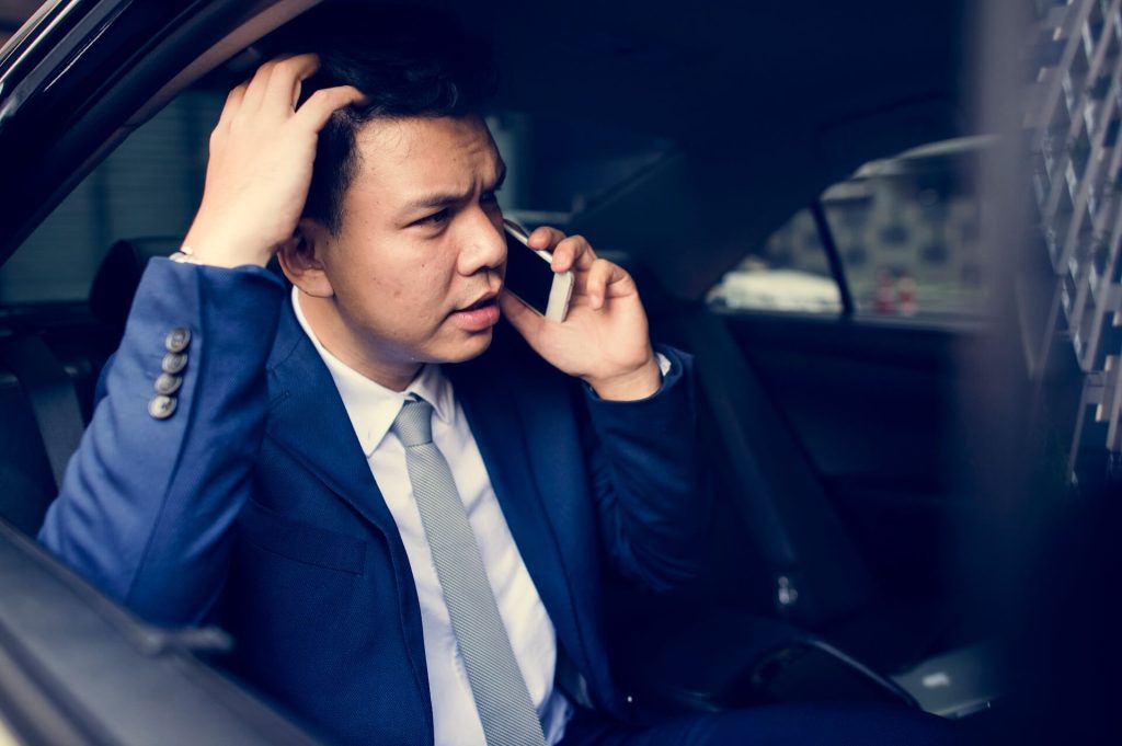 Frustrated businessman sitting in car | Featured Image for The Struggle with Selling Your Car Privately in 2023 blog from Sell My Car Queensland.